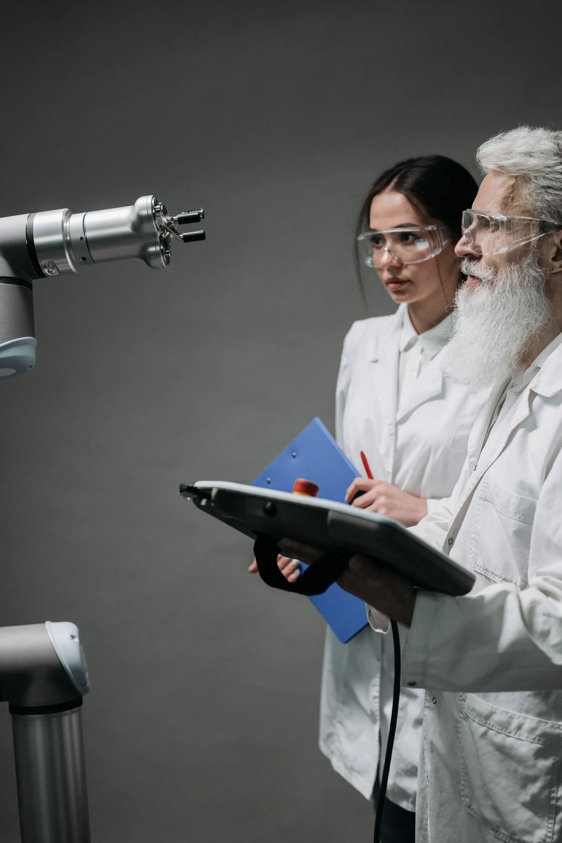 Zwei Forschende prüfen einen Roboterarm im Labor